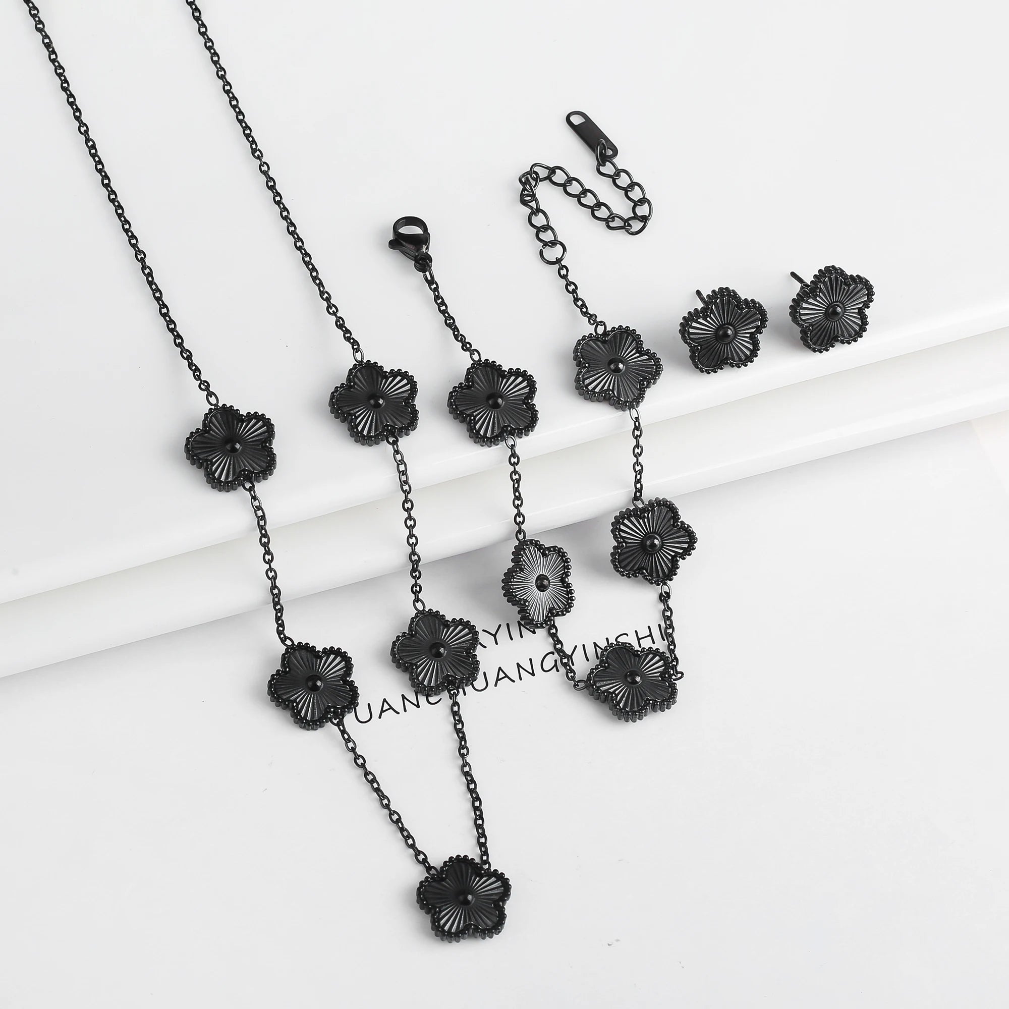 Black jewelry set with dark five-leaf flower necklaces, bracelet, and earrings