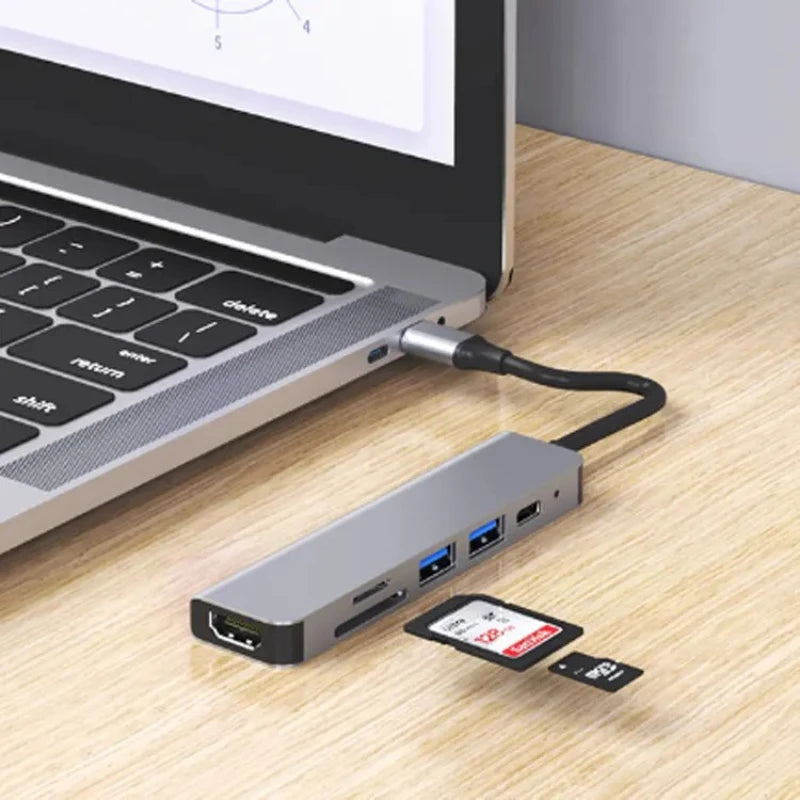 Gray USB-C docking hub with HDMI and USB ports, connected to a laptop