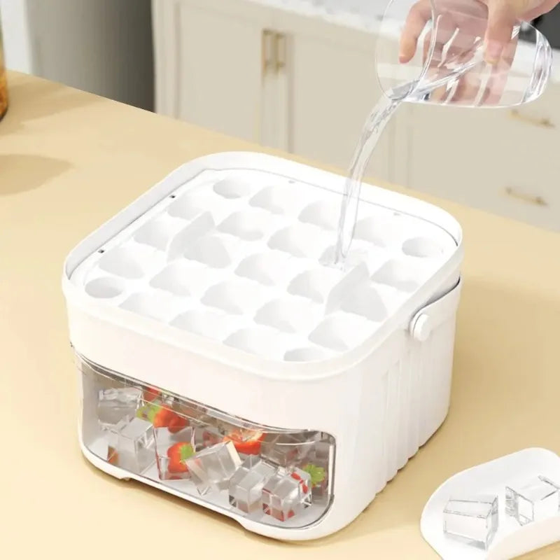 White ice cube machine with clear bin and ice mold tray under pouring spout.