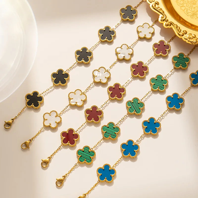 Adjustable clover charm bracelet with gold-tone chain and multicolor four-leaf charms