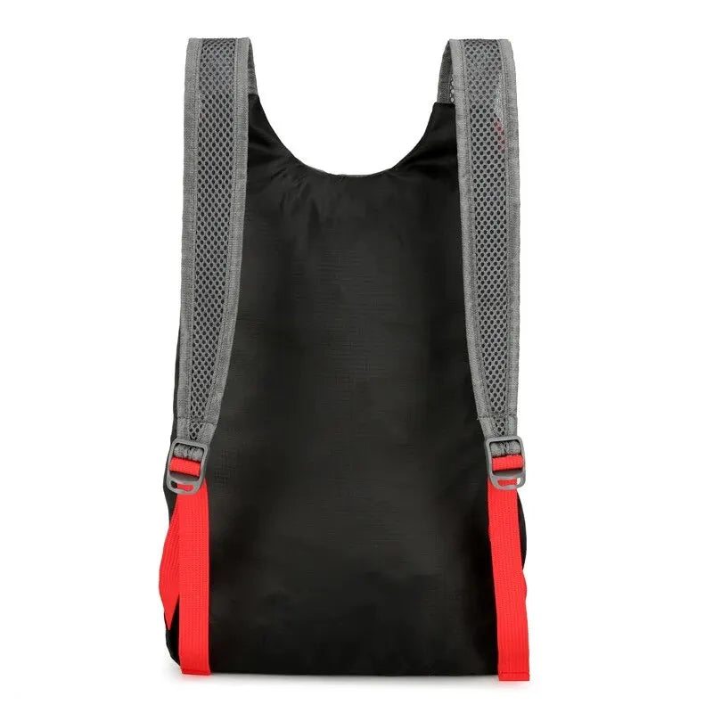 Black folding backpack back view with adjustable red strap webbing and mesh panels