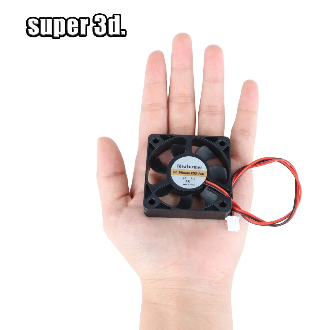 Black DC brushless cooling fan held in hand, with square frame and red wire leads.