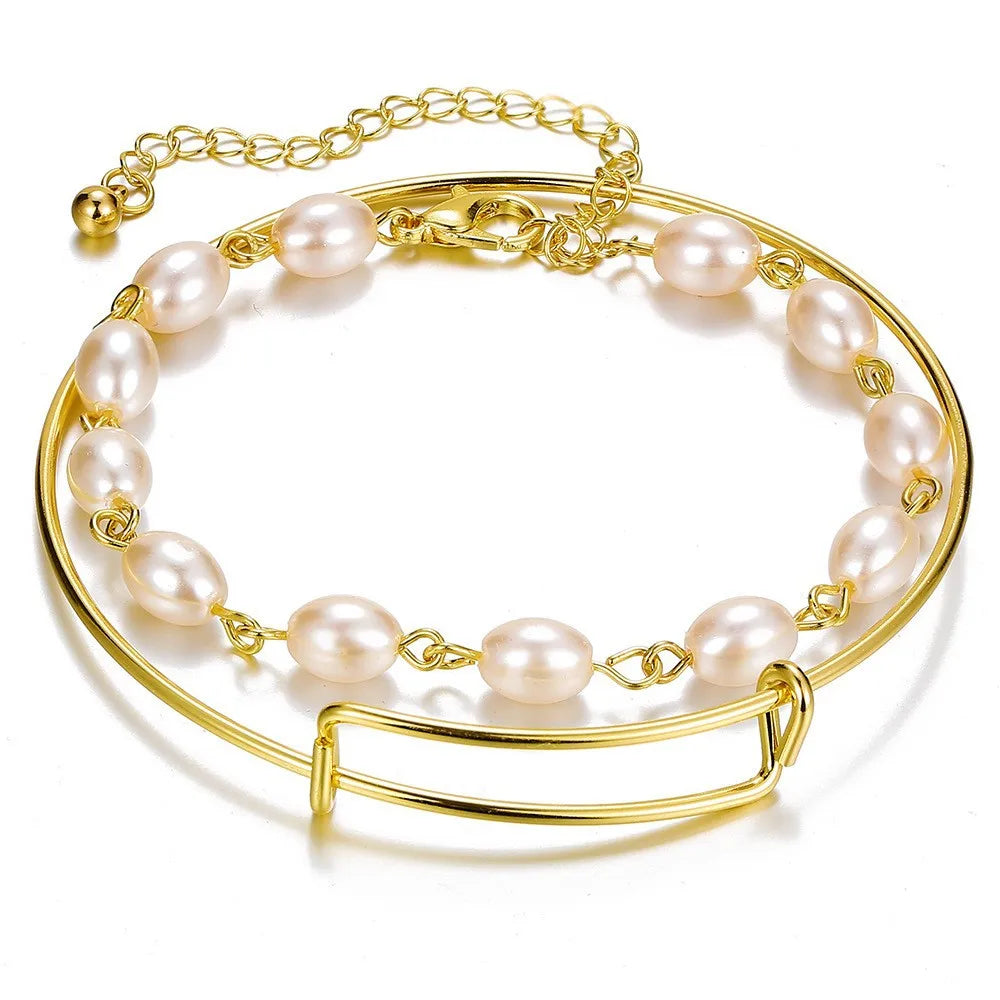 Gold-tone chain bracelet with bar clasp and white pearl bead accents