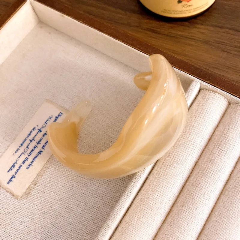 Shiny acrylic open cuff bangle in pale cream with smooth curved design