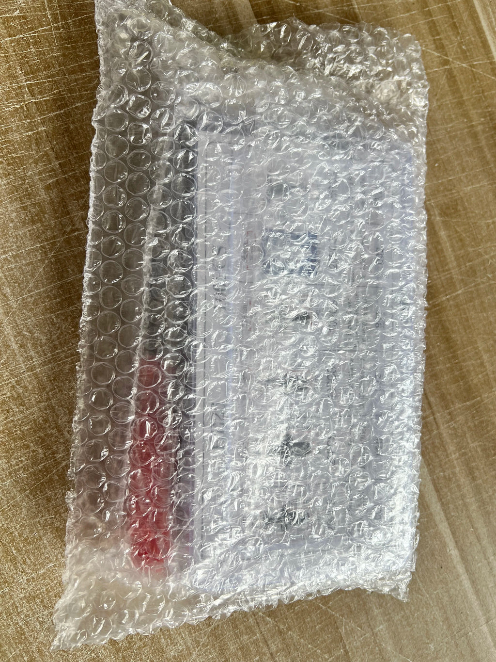 Packaged auto fastener kit wrapped in bubble cushioning on cardboard