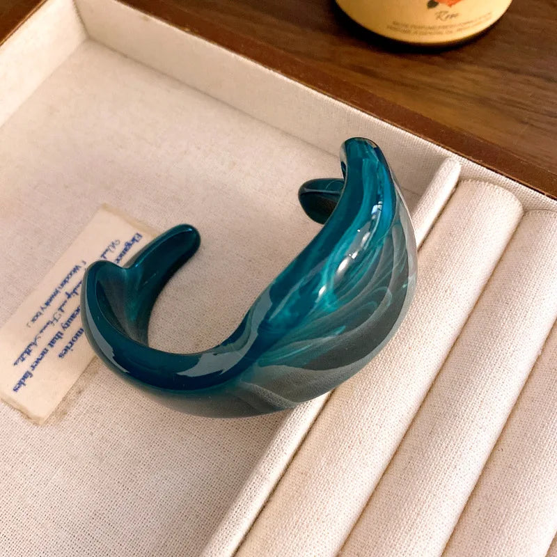 Teal translucent acrylic open bangle with shiny rounded face smudge design