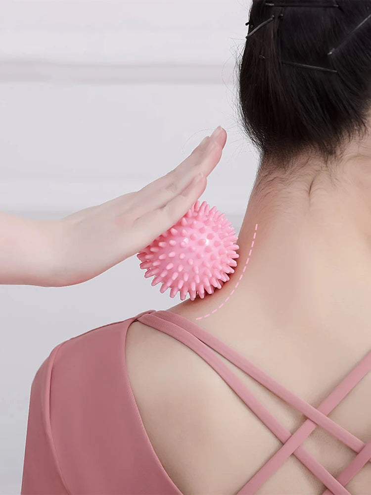 Pink spiked massage fascia ball placed at the neck and upper shoulder