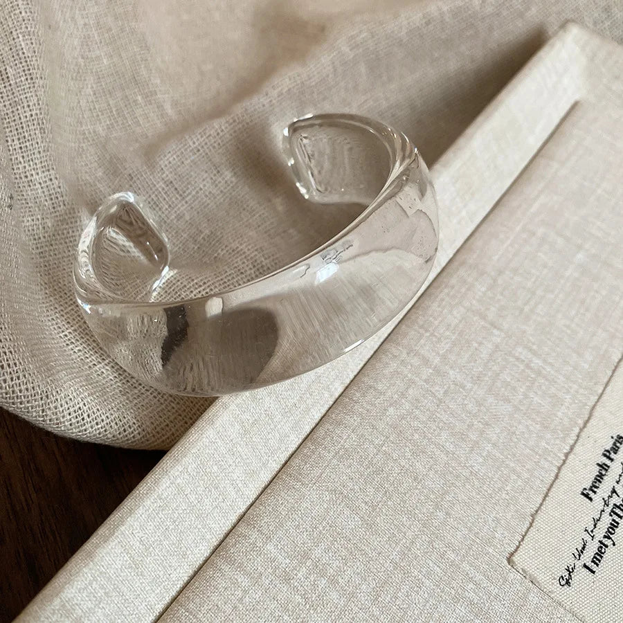 Clear translucent acrylic open bangle with shiny rounded face smudge design