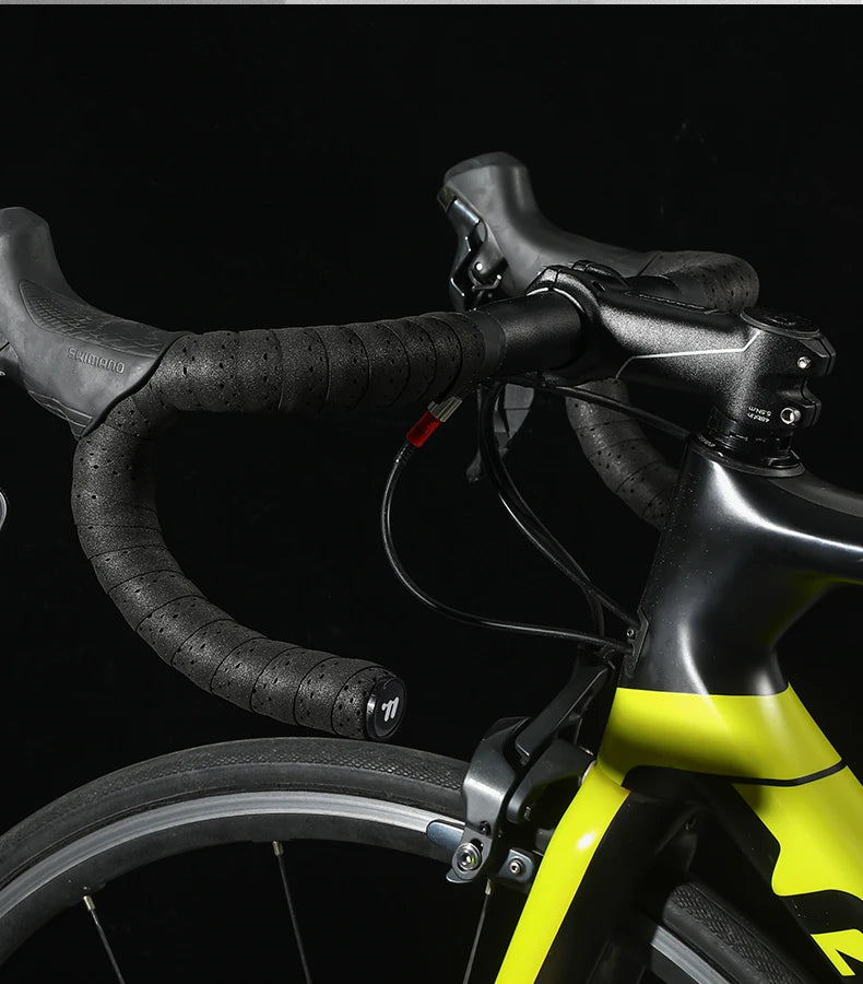 Black perforated EVA handlebar tape on bike grips, neatly wrapped along the handlebar