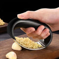 Manual garlic press with perforated metal plate for mincing garlic cloves