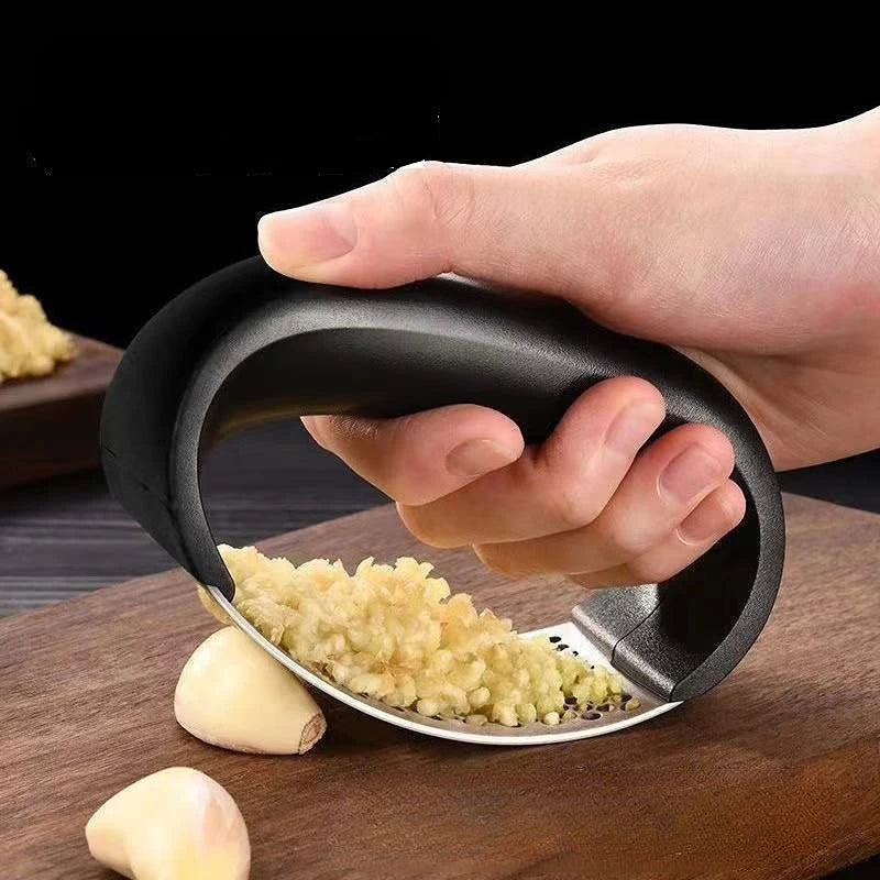 Manual garlic press with perforated metal plate for mincing garlic cloves