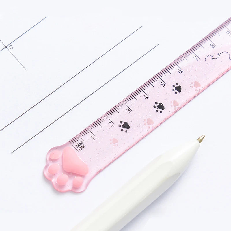 Pink cat paw plastic straight ruler, close-up of markings and paw-shaped corner tip