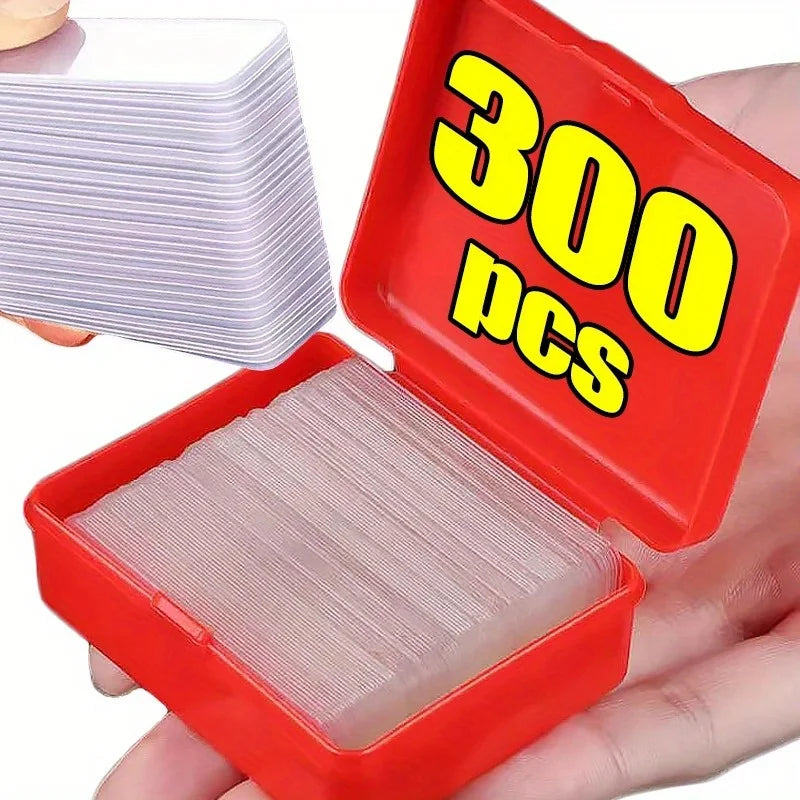 Clear double-sided adhesive tape pads in red storage box, handheld close-up.
