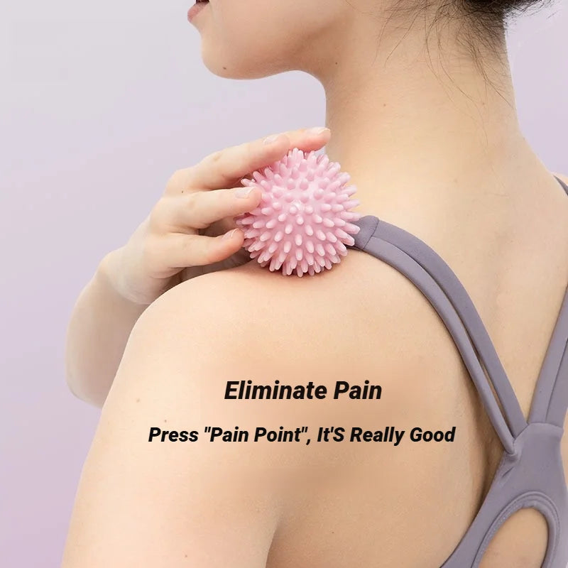 Pink spiky massage ball held against the upper back for targeted pressure