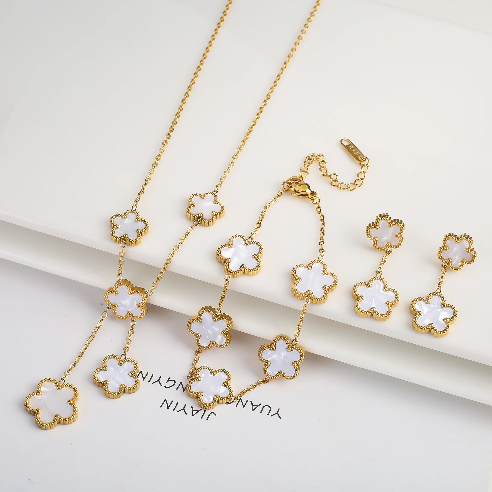 Gold-plated jewelry set with white five-leaf flower necklaces, bracelet, and drop earrings