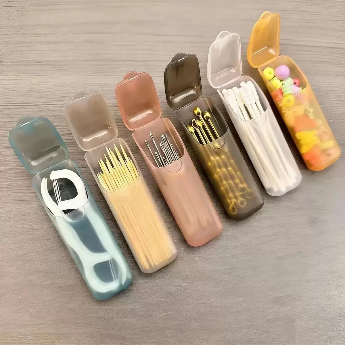 Mini portable storage box cases in assorted colors, open lids with toothpicks and swabs