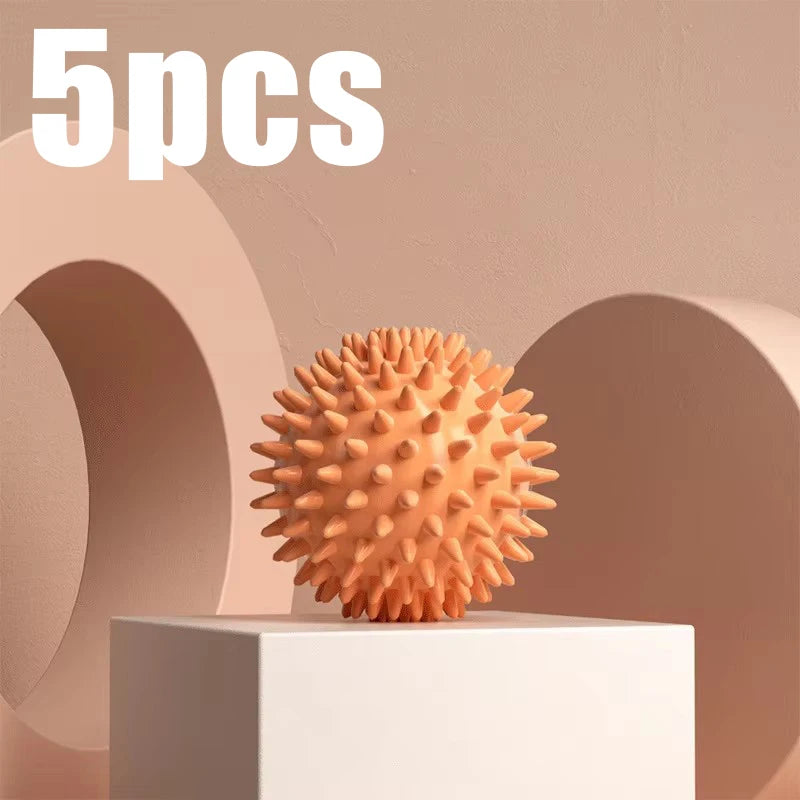 Orange spiky fascia massage ball for muscle relaxation, shown on a block pedestal