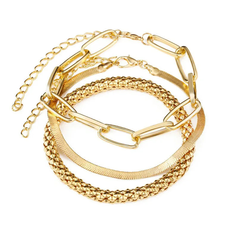 Gold-tone open bangle bracelet set with thick links, chain cuffs, and textured strand
