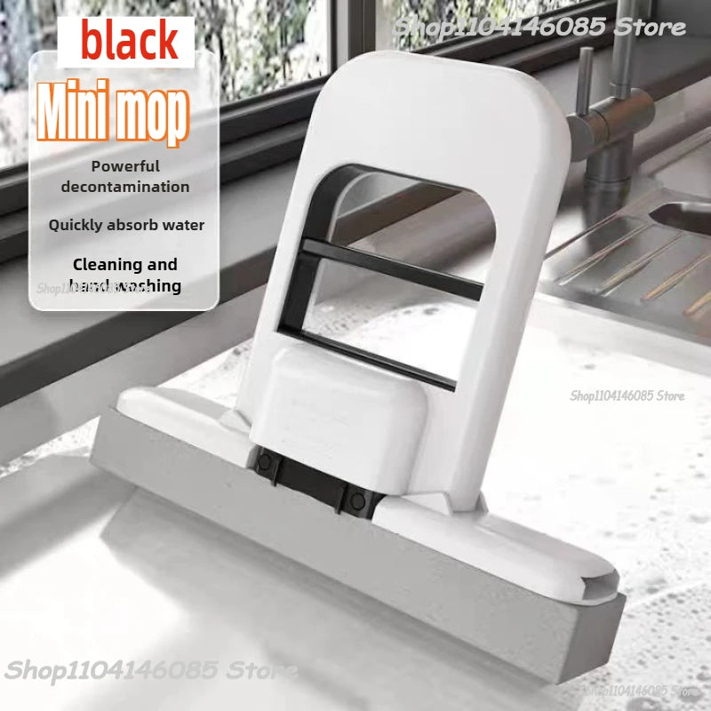 Mini handheld cleaning mop, black frame with white base and sponge pad